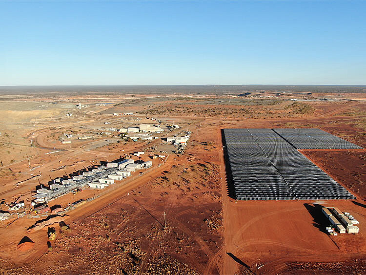 A solar plant stands in the Australian outback, right next to a battery farm.