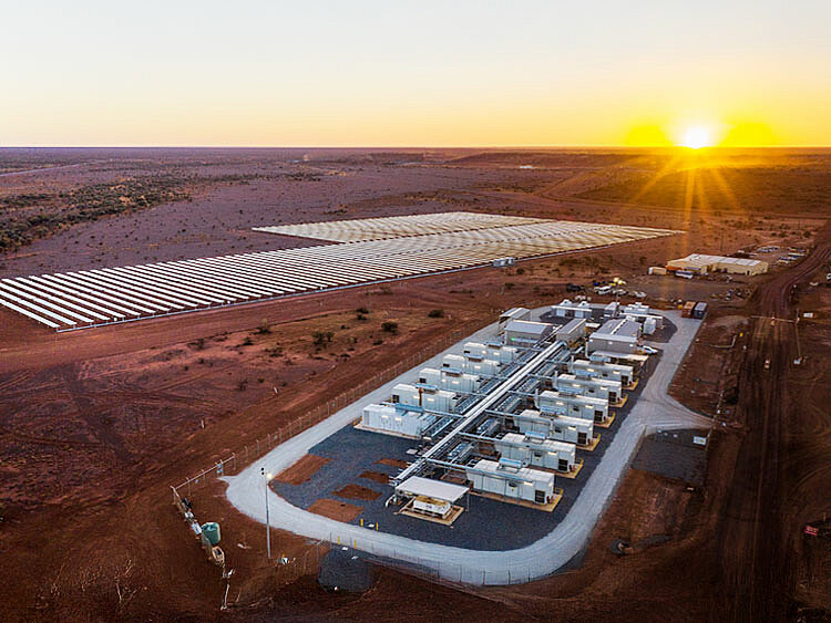 In the background, there is a PV park, and in front of it, there is a battery storage system.