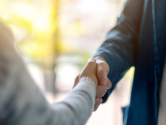 Two people shake hands.