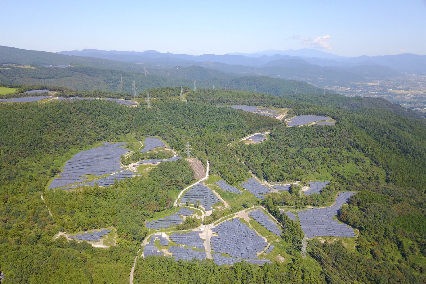 The Azuma Kofuji solar park from a bird's-eye view: The panels of the facility stand out distinctly from the surrounding trees.