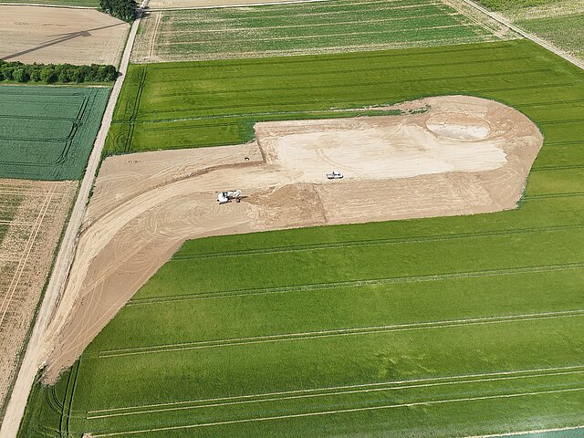 Preparatory work is being carried out on a green field.